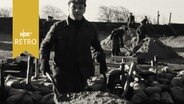 Helfer mit Schubkarre bei Aufräumarbeiten nach der Sturmflut 1962  