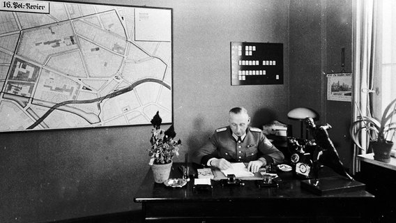 Der Polizeibeamte Wilhelm Krützfeld an seinem Schreibtisch auf dem 16. Revier in Berlin-Mitte. © CJF 