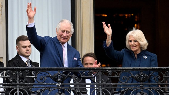König Charles III. und Camilla stehen auf dem Balkon des Hamburger Rathauses und winken. © Daniel Reinhardt/dpa +++ dpa-Bildfunk +++ Foto: Daniel Reinhardt/dpa