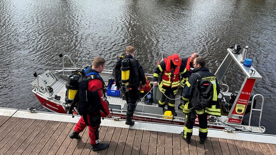 Bei einer Suchaktion im Zusammenhang mit dem vermissten Jungen Arian aus Bremervörde besteigen Feuerwehrleute ein Boot. © NDR Foto: Anna Schlieter