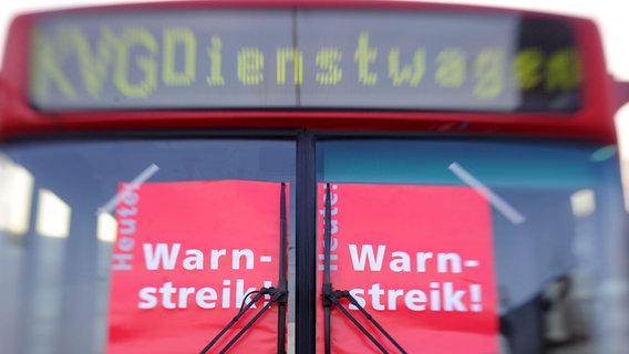 Schilder mit der Aufschrift "Warnstreik!" an einem Bus auf dem Betriebshof der Kieler Verkehrsgesellschaft in Kiel. © picture alliance / dpa Foto: Carsten Rehder