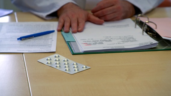 Eine Packung mit Tabletteb liegt auf einem Tisch bei einem Arzt in der Dermatologe der UKSH in Kiel. © NDR 