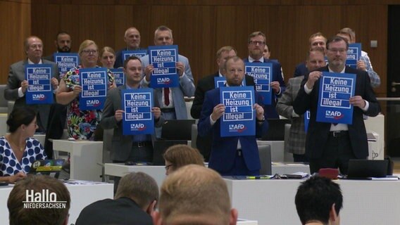 AfD-Abgeordnete halten im Landtag kleine Plakate hoch mit dem Text "Keine Heizung ist illegal". © Screenshot 
