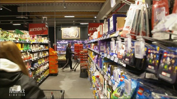 Ein Gang mit Regalen und Produkten in einem Supermarkt. © Screenshot 