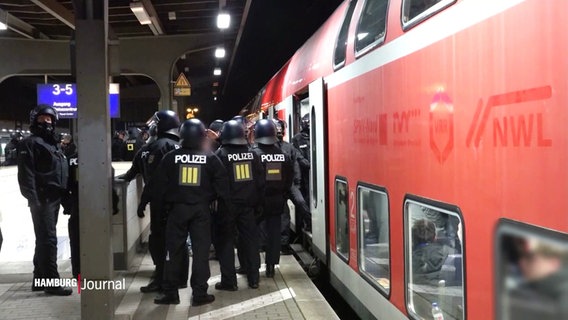 Mehrere Polizisten durchsuchen einen Fanzug des HSV in Bergedorf. © Screenshot 