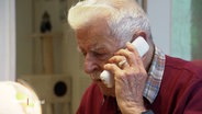 Ein älterer Herr telefoniert mit einem schnurlosen Festnetztelefon. © Screenshot 