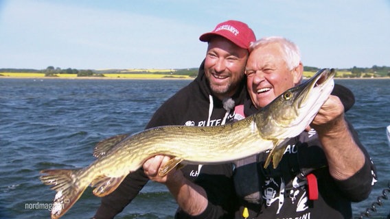 Marteria und Horst Hennings halten einen Fisch in die Kamera. © Screenshot 