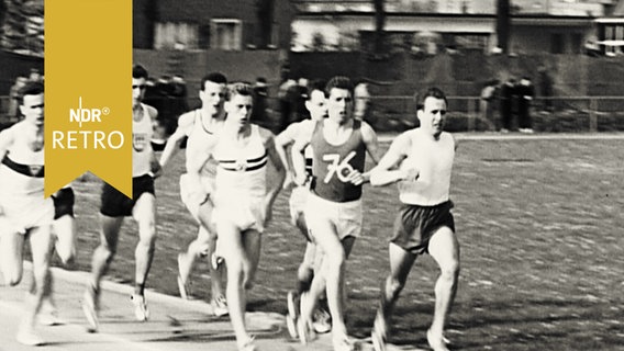 Acht Läufer im Wettkampf auf einer Leichtathletik-Bahn  