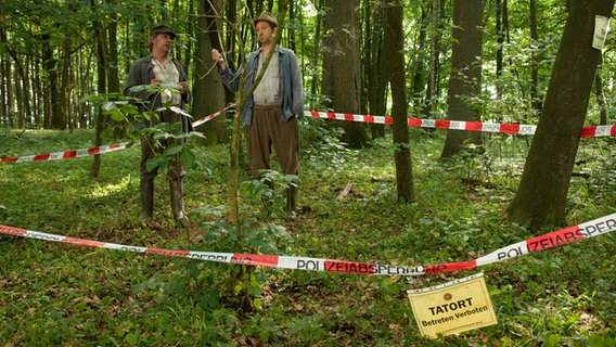 Szenenbild aus der 32. Büttenwarder-Folge "War wohl Mord": Brakelmann und Adsche untersuchen den Tatort im Wald. © NDR/Nicolas Maack Foto: Nicolas Maack