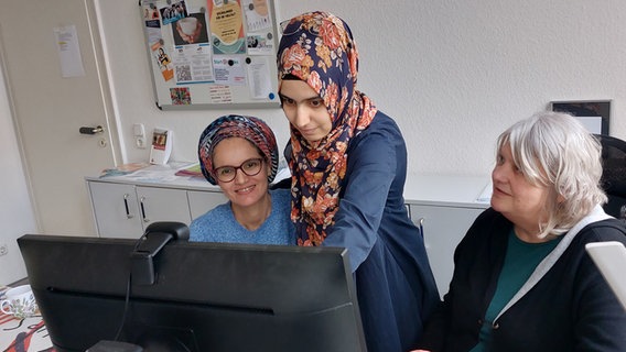 Yasemin Kocak (Mitte) und Martina Kamp (rechts) erarbeiten gemeinsam mit Niema El Moufti, welche Möglichkeiten die Marokkanerin mit ihren Qualifikationen in Deutschland hat. © NDR Foto: Katrin Schwier