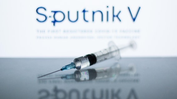 Eine Spritze mit einer Beschriftung im Hintergrund "Sputnik V" © picture alliance / ZUMAPRESS Foto: Thiago Prudencio