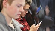 Teenagers are sitting on a train. © picture alliance / KEYSTONE Photo: Christof Schuerpf