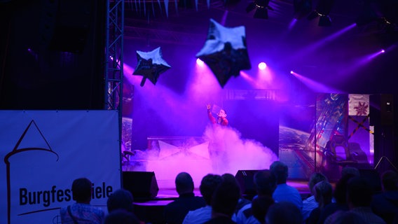 Eine Frau steht im Nebel auf einer lila beleuchteten Bühne © Burgfestspiele Plau am See/Diedrichsen 