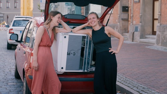 Zwei Frauen lehnen an einem Auto © Real Fiction 