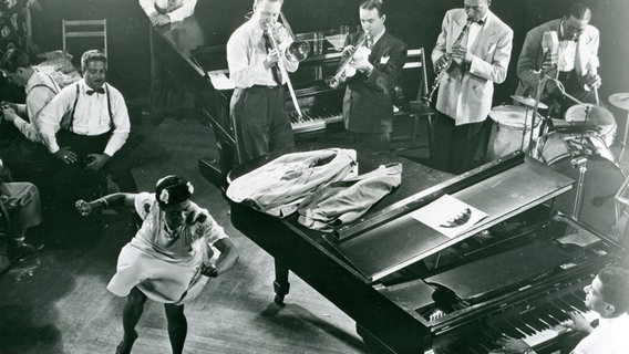 Die Tänzerin Pearl Primus tanzt umgeben von einer Band im Cafe Society in New York im Jahr 1945. © picture alliance / akg-images | akg-images 