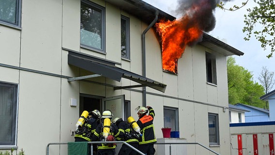Einsatzkräfte der Feuerwehr löschen einen Brand in einer Flüchtlingsunterkunft in Hamburg. © HamburgNews 