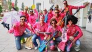   People dressed in colorful clothes celebrate Schlagermove in the St. Pauli district of Hamburg. © dpa Photographer: Georg Wendt 