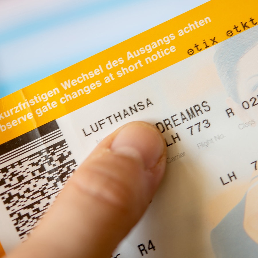 Ein Mann hält ein Flugticket der Lufthansa in der Hand © picture alliance / dpa-tmn | Foto: Zacharie Scheurer
