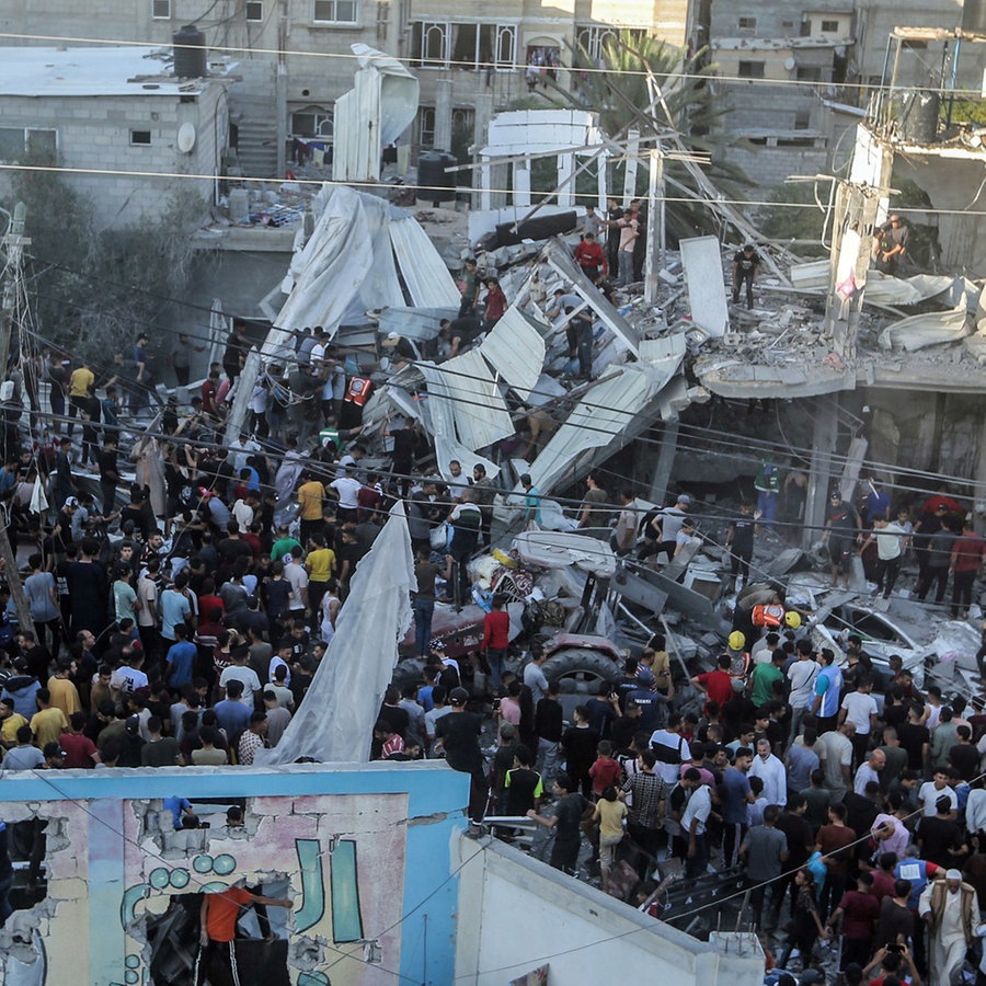 In Chan Junis inspizieren Palästinenser die Trümmer nach einem israelischen Luftangriff in der Nähe einer Schule des Hilfswerks der Vereinten Nationen für Palästinaflüchtlinge. (Foto vom 21.10.2023) © Mohammed Talatene/dpa 
