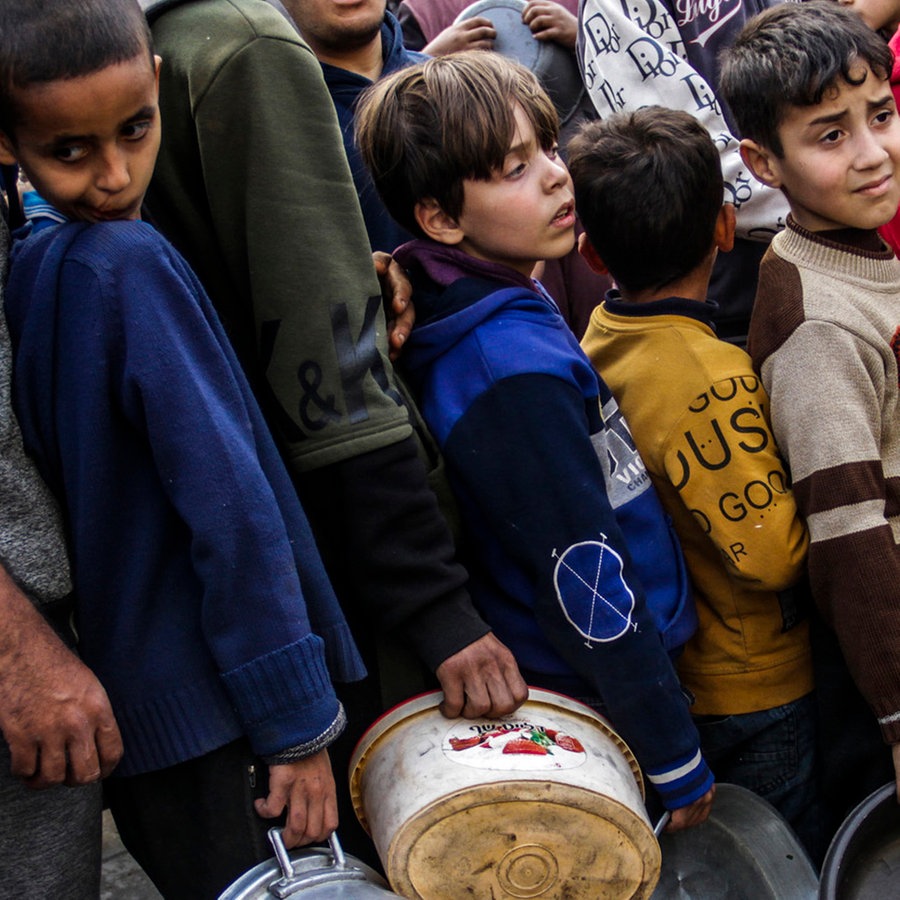 Kinder stehen im Flüchtlingslager Jabalia an, um während des heiligen muslimischen Fastenmonats Ramadan kostenlose Mahlzeiten zu erhalten. © Mahmoud Issa/dpa 