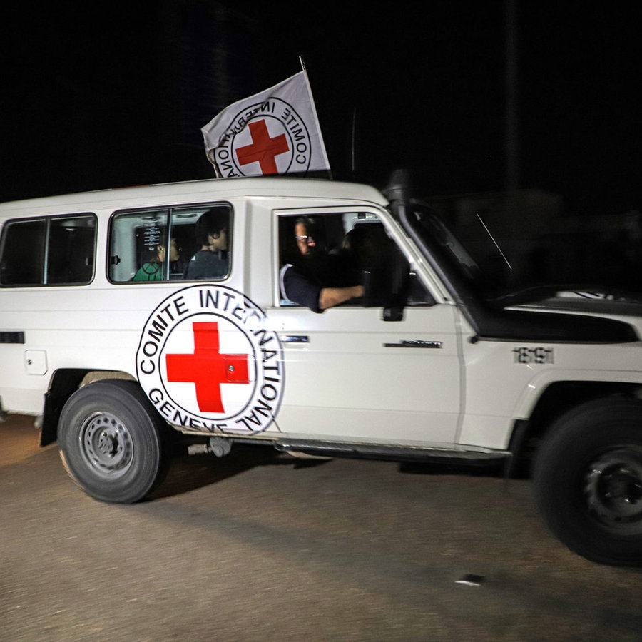 Ein Fahrzeug des Roten Kreuzes fährt im Dunklen im Gazastreifen auf einer Straße Richtung Grenzübergang nach Ägypten. © dpa-Bildfunk/AP Foto: Xin Hua