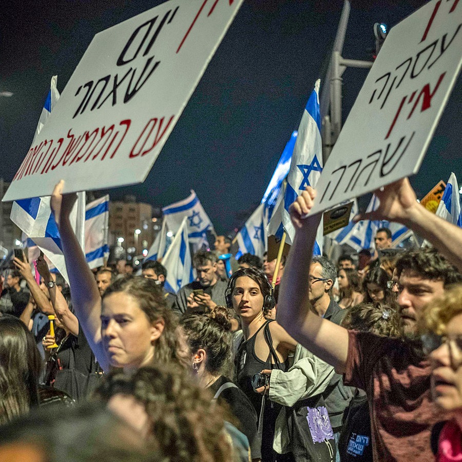 In einer Menschenmenge werden bei einer Demonstration in Jerusalem in Israel Plakate mit regierungskritischem Inhalt hochgehalten. © dpa-Bildfunk Foto: Ilia Yefimovich