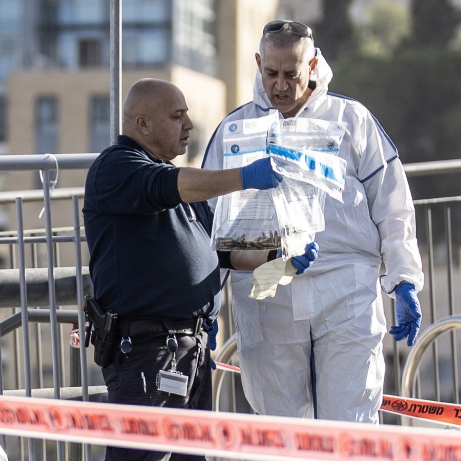 Ermittler der Polizei untersuchen Gegenstände am Tatort nach einem Anschlag in Israel. © picture alliance / Anadolu | Mostafa Alkharouf 