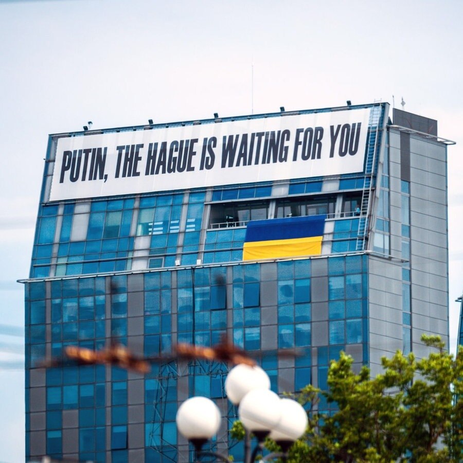 Ein Transparent mit der Aufschrift „Putin, The Hague is waiting for you“ (Putin, Den Haag wartet auf dich) hängt an einem Hochhaus in Vilnius. © picture alliance/dpa | Michael Kappeler Foto: Michael Kappeler