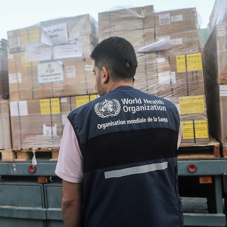 Ein Arbeiter beobachtet die von der Weltgesundheitsorganisation (WHO) gesandten medizinischen Hilfspakete. © dpa Foto: Mohammed Talatene