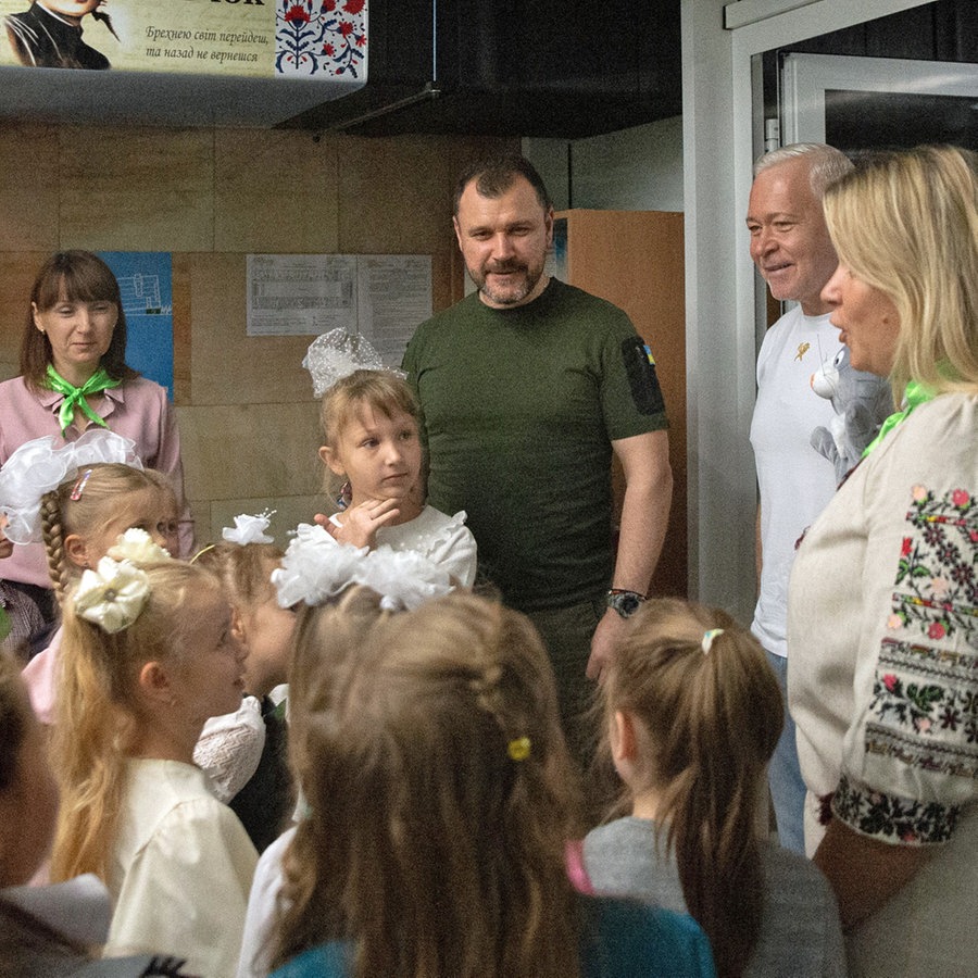 Der Bürgermeister von Charkiw, Ihor Terechow (2. von rechts), besucht am ersten Schultag ein Klassenzimmer, das in einer U-Bahn-Station eingerichtet wurde. © ZUMA Press Wire/dpa Foto: Madeleine Kelly