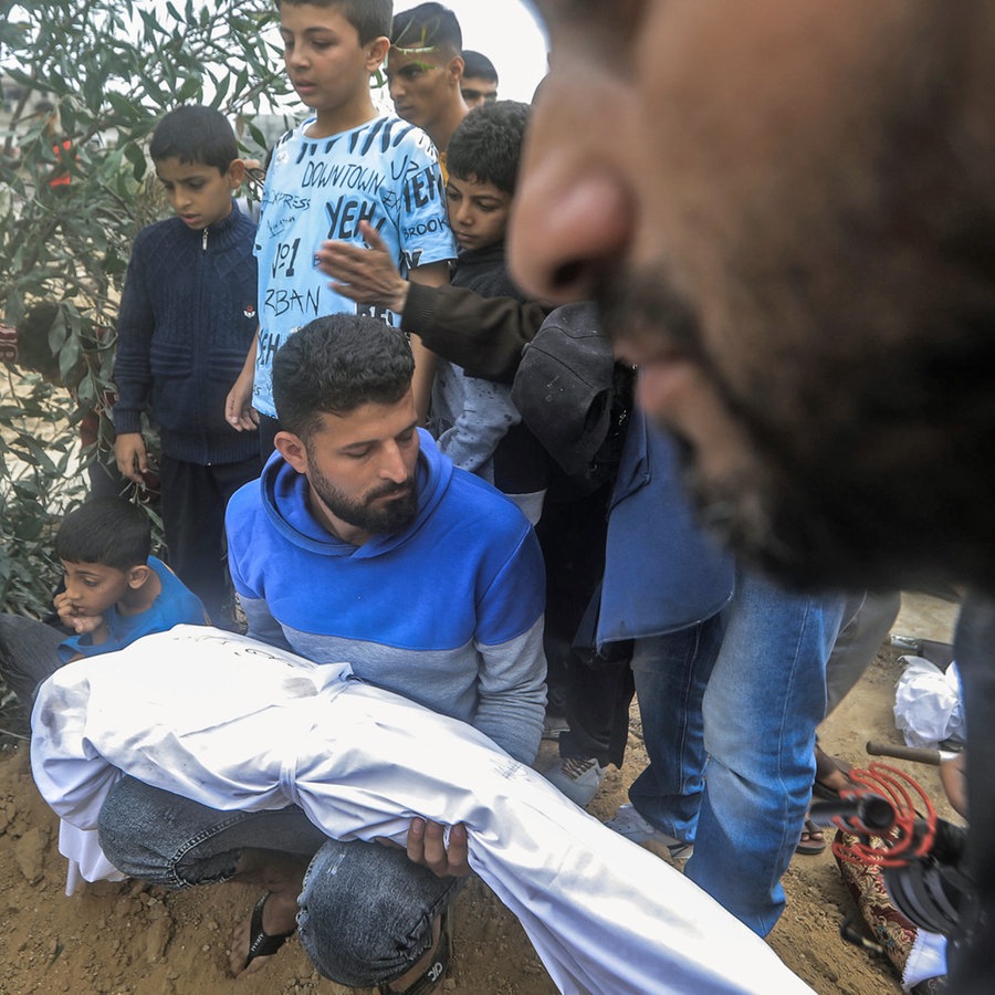Mitglieder einer Familie begraben die Leichen ihrer Angehörigen, die nach einem israelischen Bombenangriff im südlichen Gazastreifen getötet wurden. © dpa Foto: Mohammed Talatene