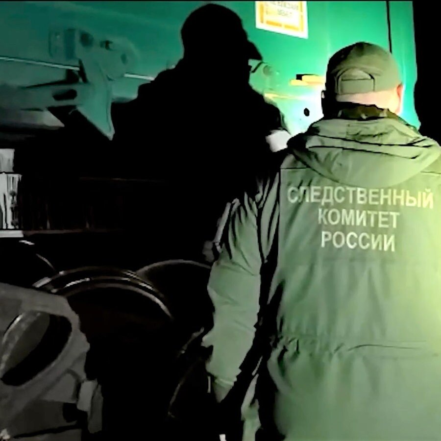 Zwei Männer untersuchen einen Nahe der ukrainischen Grenze entgleisten, russischen Güterzug © picture alliance/dpa/Russian Investigative Committee Foto: Russian Investigative Committee