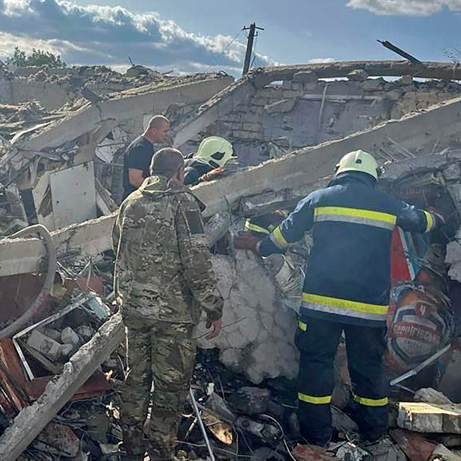 Rettungskräfte suchen nach Opfern eines russischen Raketenangriffs, bei dem mindestens 47 Menschen in dem Dorf Hrosa in der Nähe von Charkiw (Ukraine) getötet wurden. © Uncredited/Ukrainian Presidential Press Office/AP 