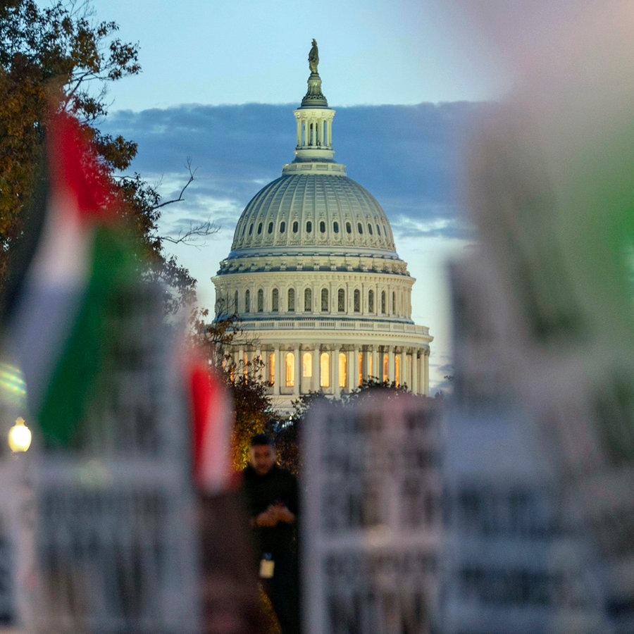 Das US-Kapitol ist zu sehen, während sich Demonstranten bei einer pro-palästinensischen Demonstration für eine Feuerpause im Gazastreifen versammeln. © AP/dpa Foto: Jose Luis Magana