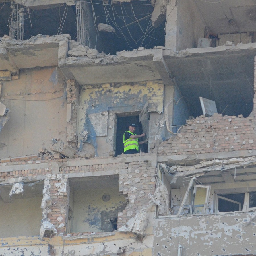 Ein Mann steht in einem Gebäude, das bei dem dritten russischen Luftangriff auf die ukrainische Hauptstadt innerhalb der letzten 24 Stunden stark beschädigt wurden. © dpa-Bildfunk Foto:  Aleksandr Gusev