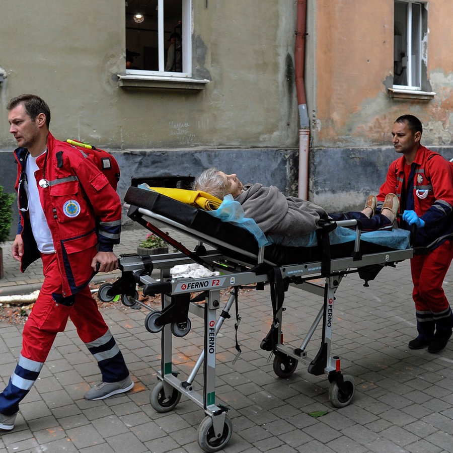 Zwei Sanitäter transportieren eine ältere Frau, nach einem Raketenangriff auf die Stadt Lemberg (Lwiw, Ukraine). © AP/dpa Foto: Mykola Tys