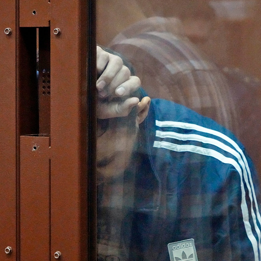 Ein Tatverdächtiger des Terroranschlags auf die Konzerthalle Crocus City Hall in Moskau hält sich in einem Glaskäfig im Bezirksgericht Basmanny auf. © AP Foto: Alexander Zemlianichenko