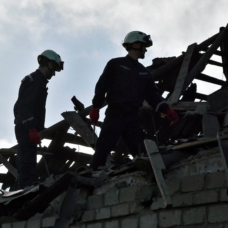 Rettungskräfte räumen die Trümmer der zerstörten Häuser nach einem russischen Drohnenangriff auf ein Wohnviertel in Saporischschja im Südosten der Ukraine. © AP Foto: Andriy Andriyenko
