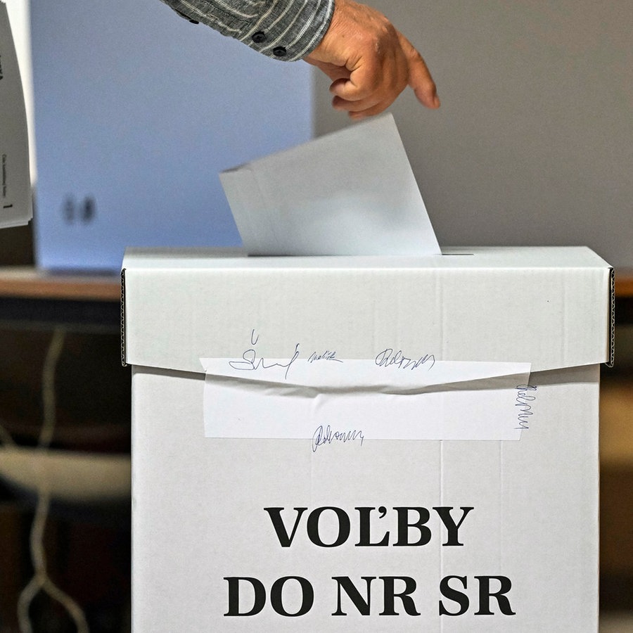 Ein Mann steckt bei den vorgezogenen Parlamentswahlen in der Slowakai seinen Stimmzettel in eine Wahlurne. © TASR/dpa Foto: Jaroslav Novák