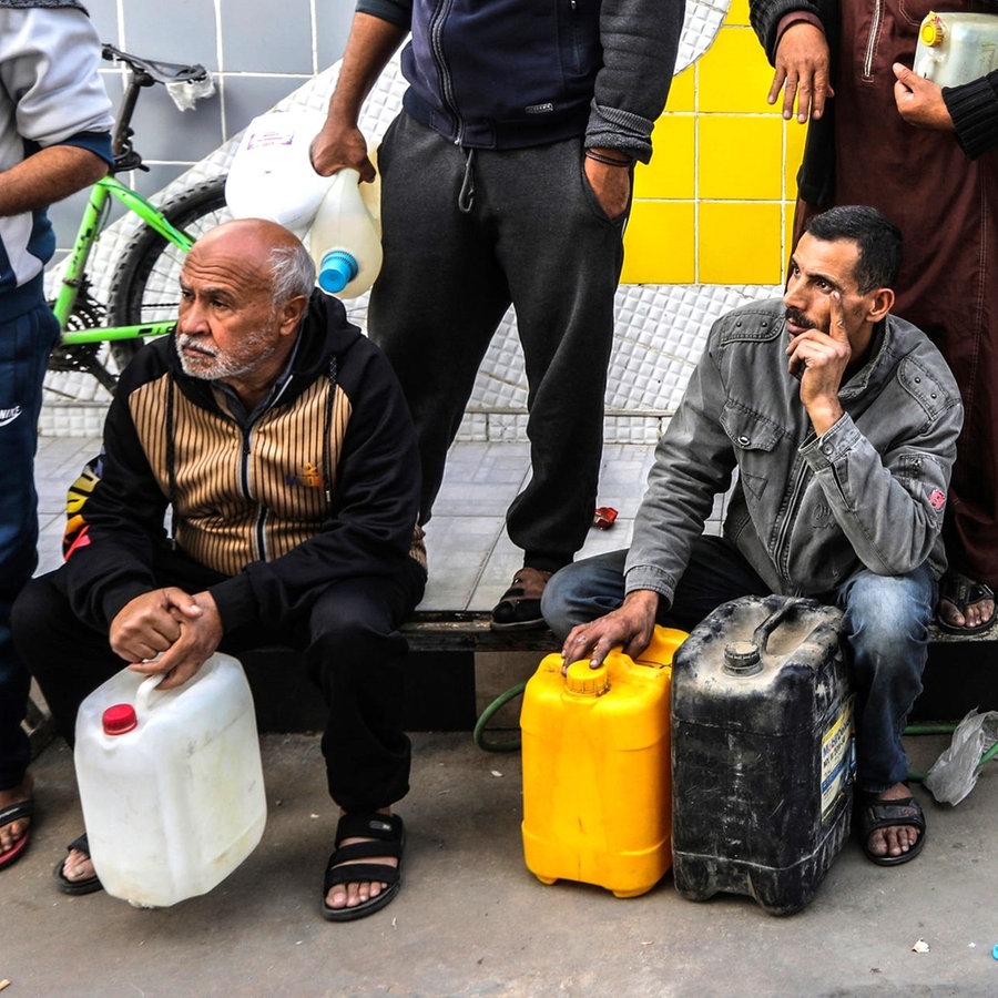 Palästinensische Gebiete, Rafah: Palästinenser warten am dritten Tag der Waffenruhe im Gazastreifen mit Kanistern in der Hand vor einer Tankstelle, um Benzin und Diesel zu tanken. © dpa Foto: Abed Rahim Khatib