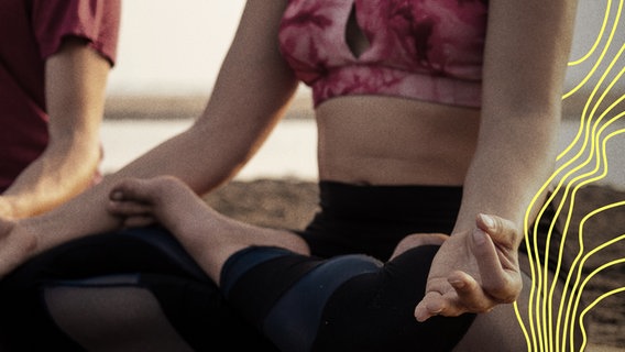 Eine Frau meditiert auf einer Yoga-Matte im Schneidersitz (Symbolbild). © Imago Images 