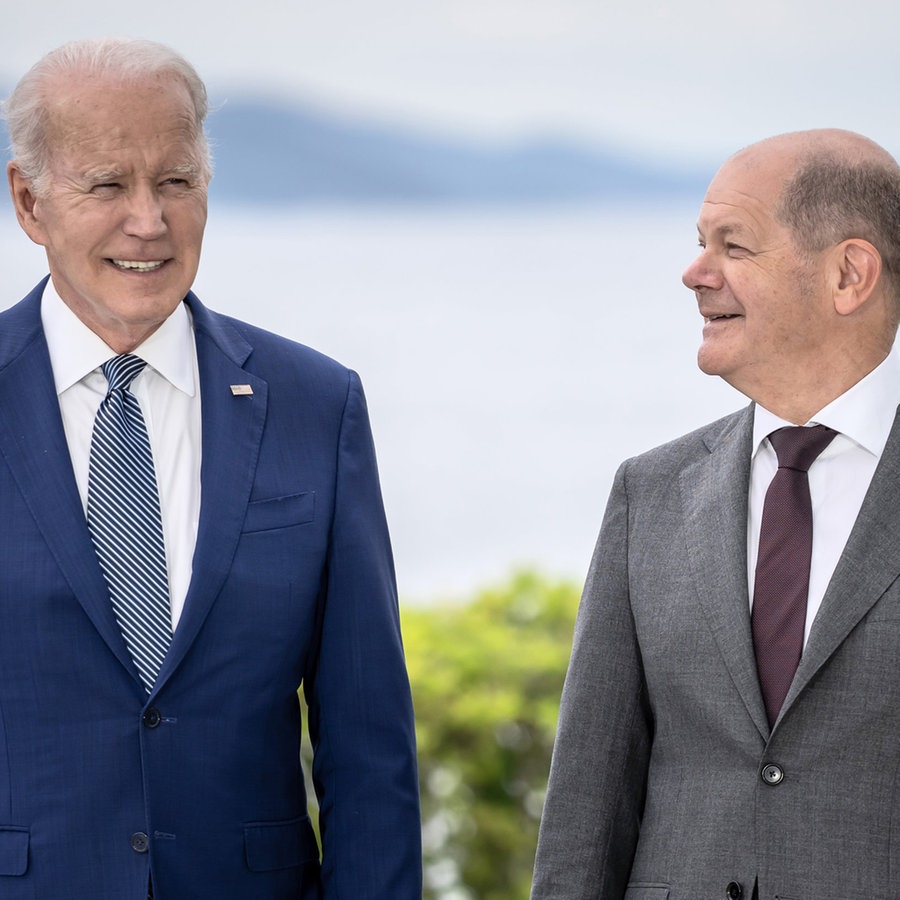 Der US-Präsident Joe Biden und der deutsche Bundeskanzler Olaf Scholz stehen im Freien nebeneinander. © dpa Foto: Michael Kappeler