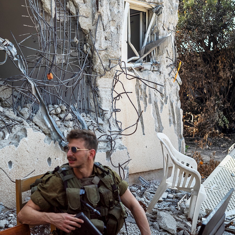 Israelische Soldaten zwischen zerstörten Häusern im Kibbuz Kfar Aza. © picture alliance Foto: Ilia Yefimovich