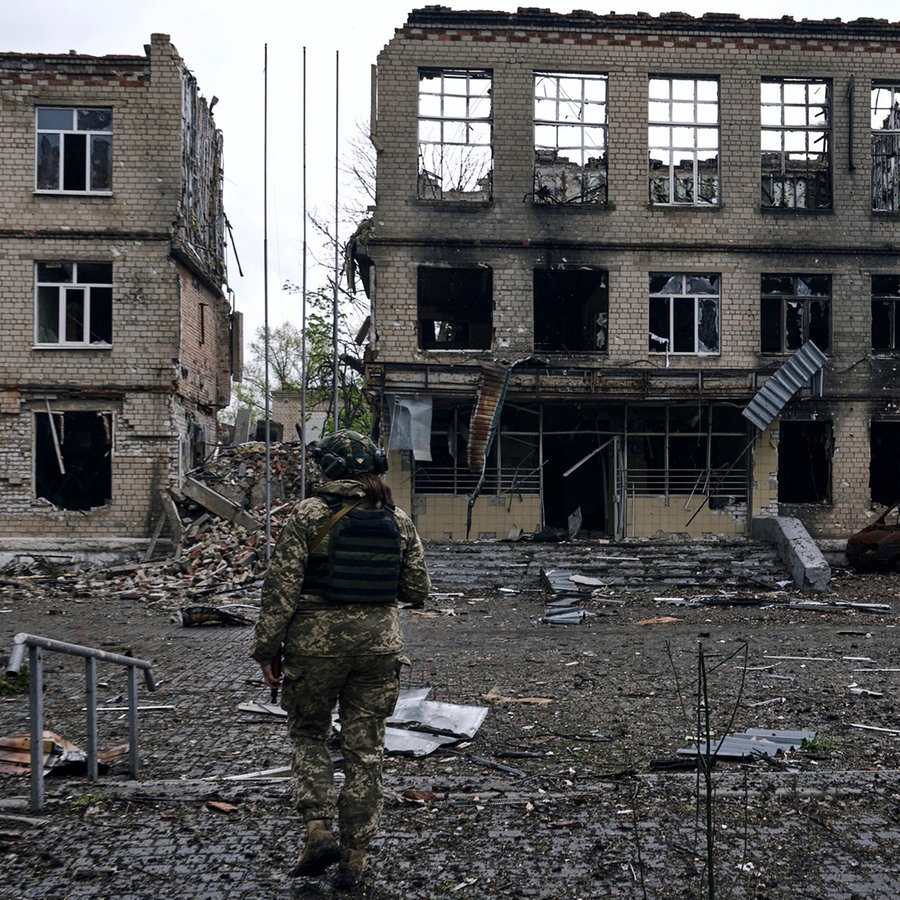 Ein ukrainischer Soldat vor zerstörten Häusern in Awdijiwka in der Region Donezk (Archiv) © LIBKOS/AP/dpa Foto: LIBKOS