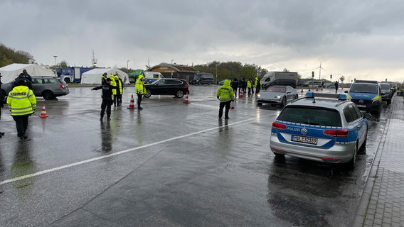 Zahlreiche Polizeibeamte und -fahrzeuge stehen auf einem Parkplatz an der A24 bei Wittenburg. Sie kontrollieren Autofahrerinnen und Autofahrer im großen Stil auf Drogeneinfluss. © NDR Foto: Christoph Loose