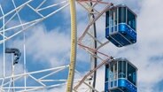 Three gondolas of a ferris wheel against a changing sky. © Messe Hannover Photo: Rainer Jensen