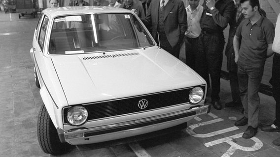 Mehrere Personen inspizieren 1974 den neuen VW Golf. © picture alliance / Wolfgang Weihs Foto: Wolfgang Weihs