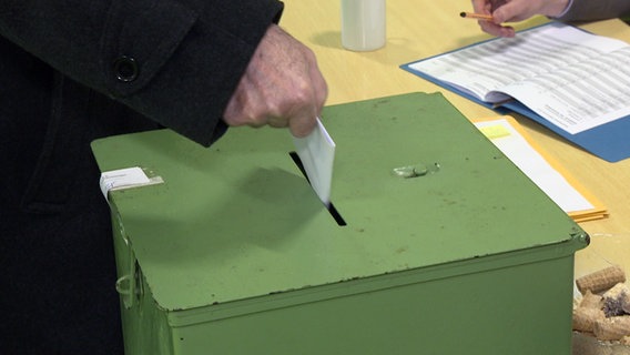 Ein Mann wirft seinen Stimmzettel in eine Box. © NDR Foto: Matthias Schuch