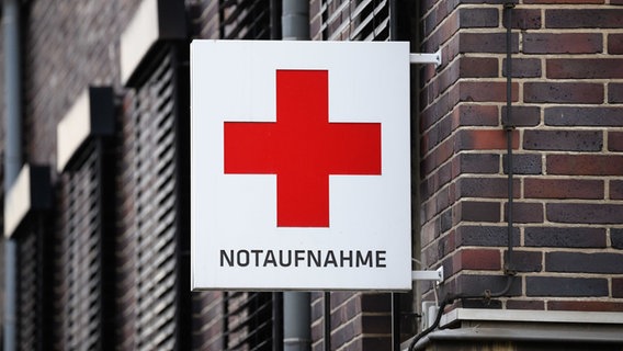Ein Schild mit einem roten Kreuz verweist auf die Notaufnahme eines Krankenhauses in Hannover. © Julian Stratenschulte/dpa Foto: Julian Stratenschulte/dpa