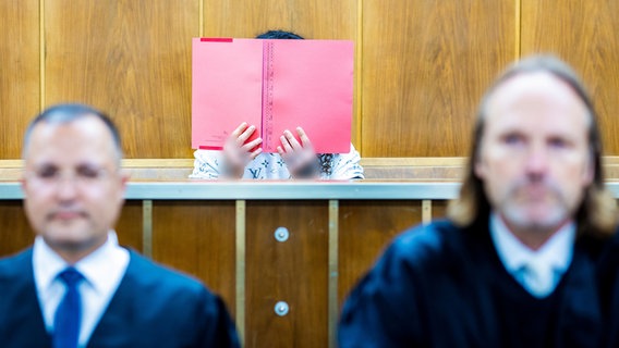 Der Angeklagte (M) sitzt bei Prozessauftakt in einem Saal im Landgericht Hannover neben seinen Rechtsanwälten Eugen Ortmann (l) und Mario Prigge (r). © picture alliance/dpa Foto: Moritz Frankenberg